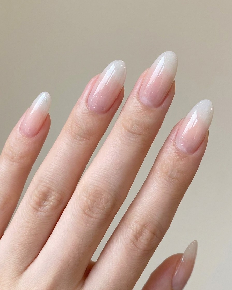 Una mano descansando dentro de una lámpara profesional de uñas UV/LED, curando el degradado de gel aplicado.