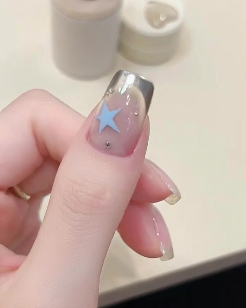 Mano con uñas pintadas dentro de una lámpara UV encendida.