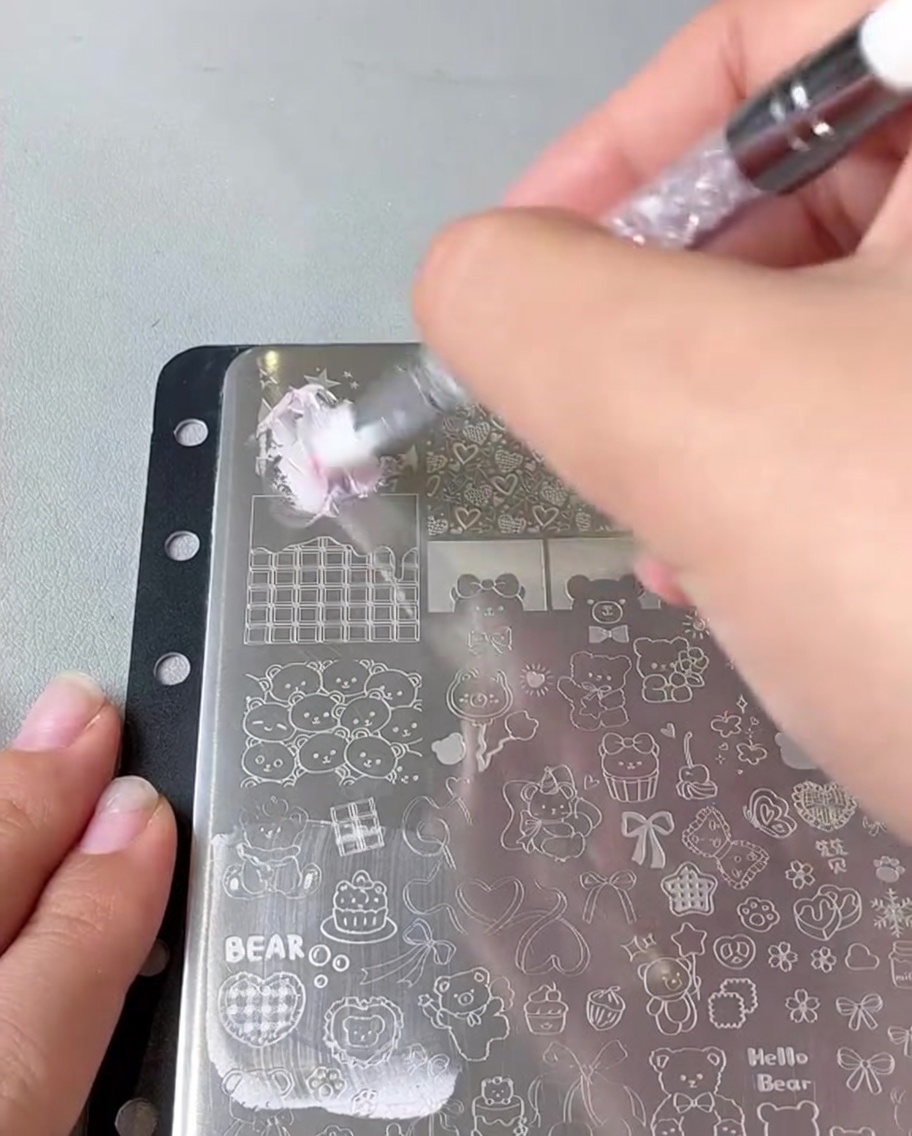 Un raspador deslizándose sobre una placa de estampación de metal.