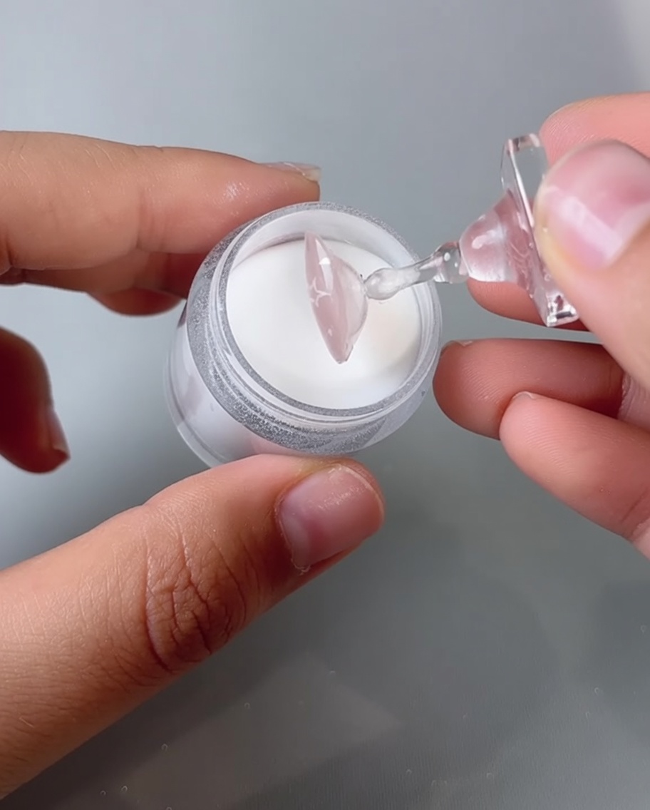 Una uña siendo colocada en una lámpara de uñas UV/LED para curar.