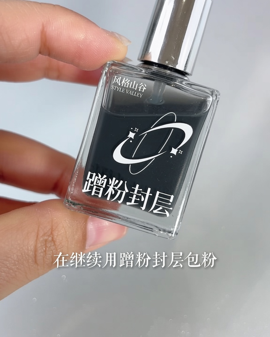 Un pincel aplicando top coat transparente sobre una uña con degradado espejo.