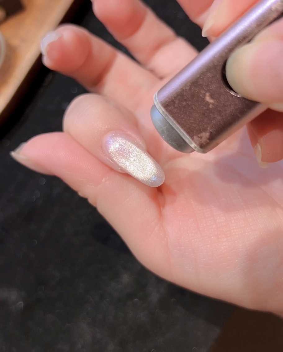 Vista de primer plano de una mano en la lámpara UV/LED, con las uñas recibiendo luz.