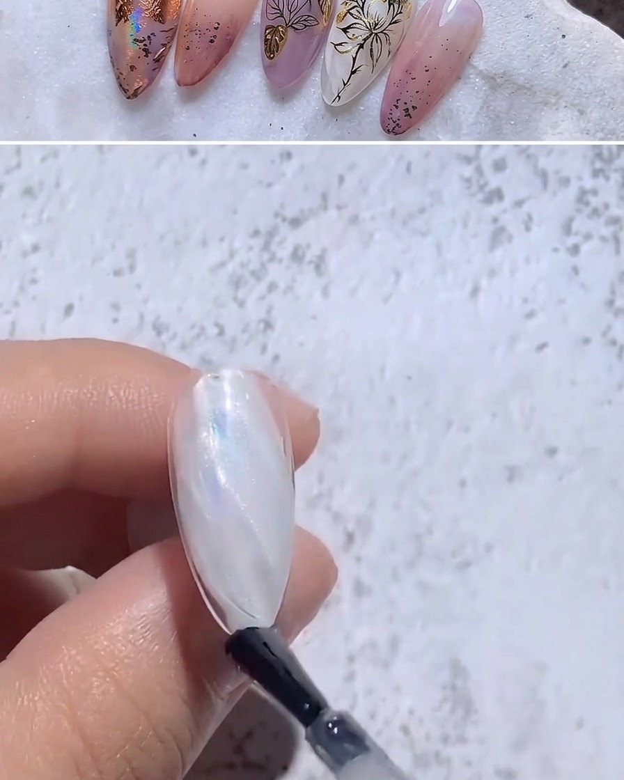 Un pincel aplicando top coat transparente sobre una uña con foil iridiscente.