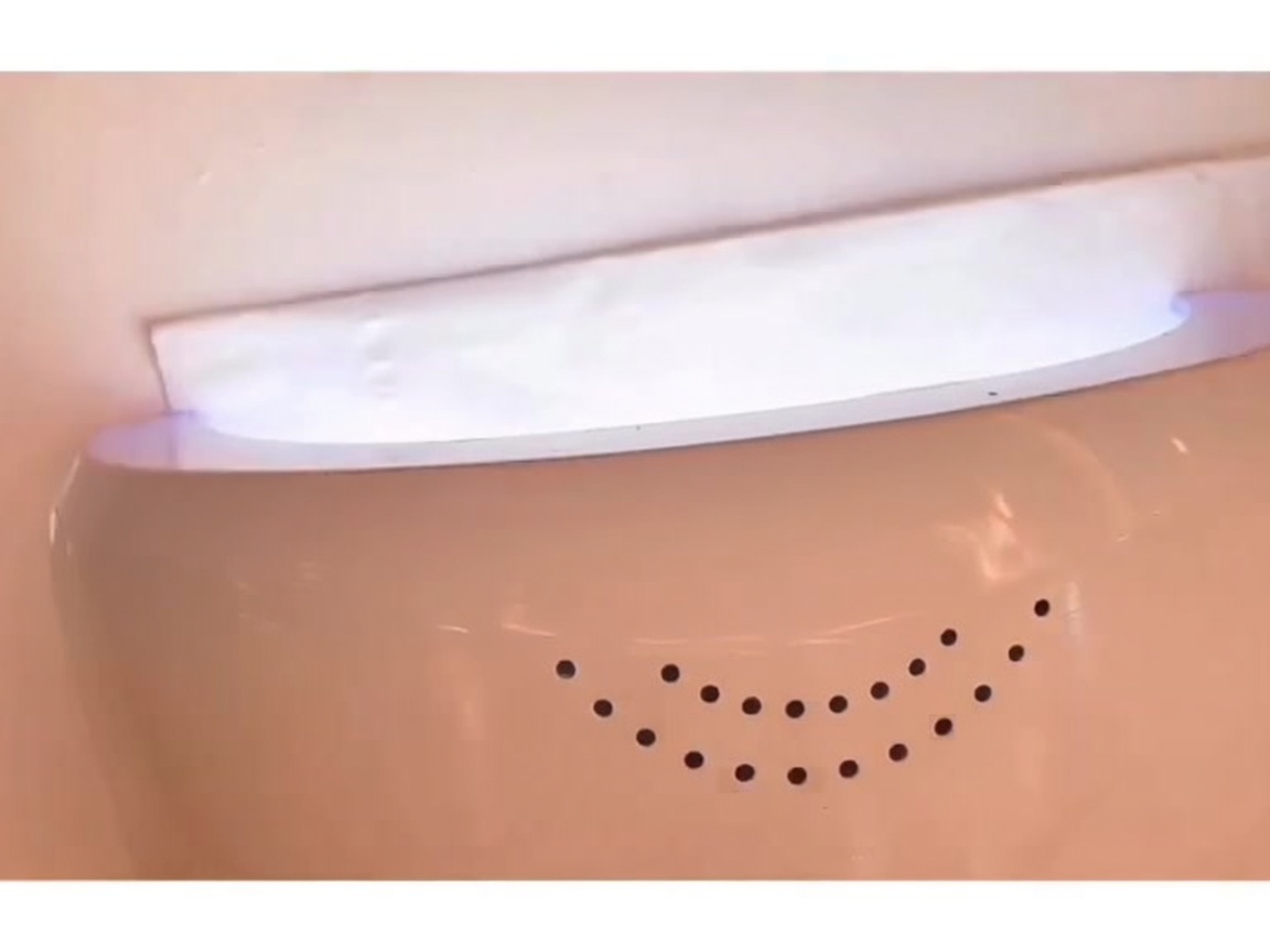 Una mano dentro de una lámpara LED de uñas con la luz encendida, curando el gel base.