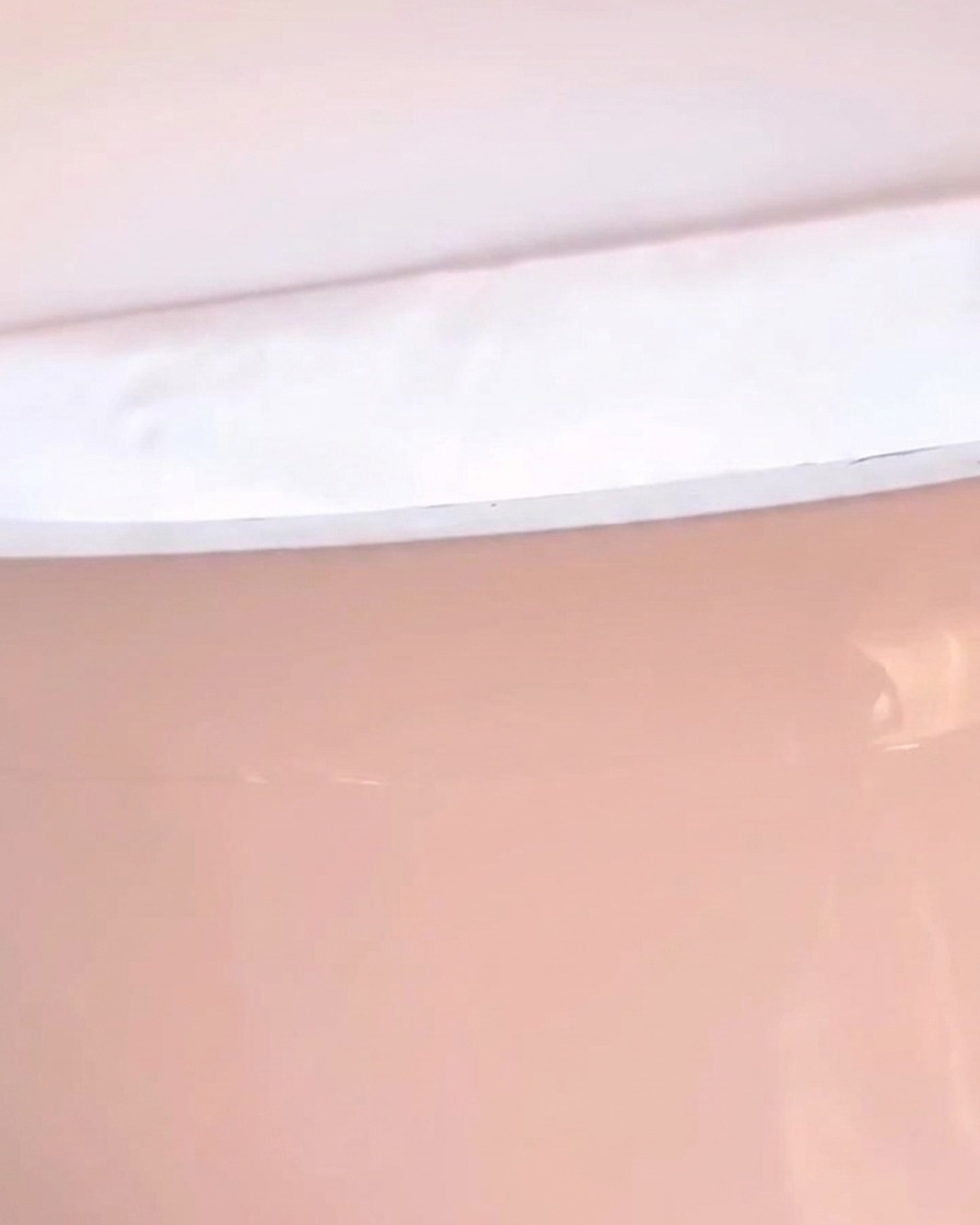 Primer plano de una mano descansando dentro de una lámpara LED con luz rosada.