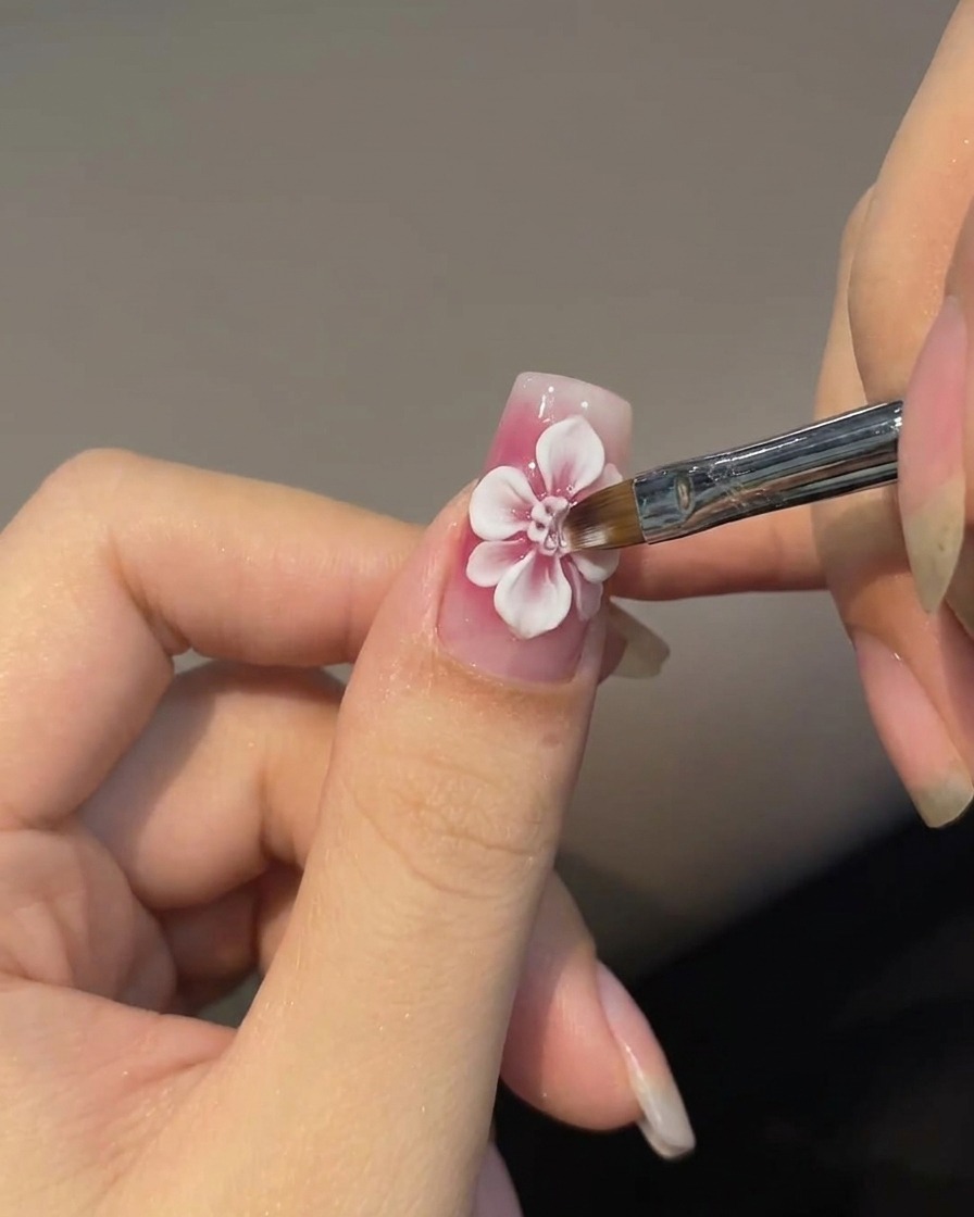 Un pincel biselado creando pétalos blancos difuminados alrededor de una rosa roja.