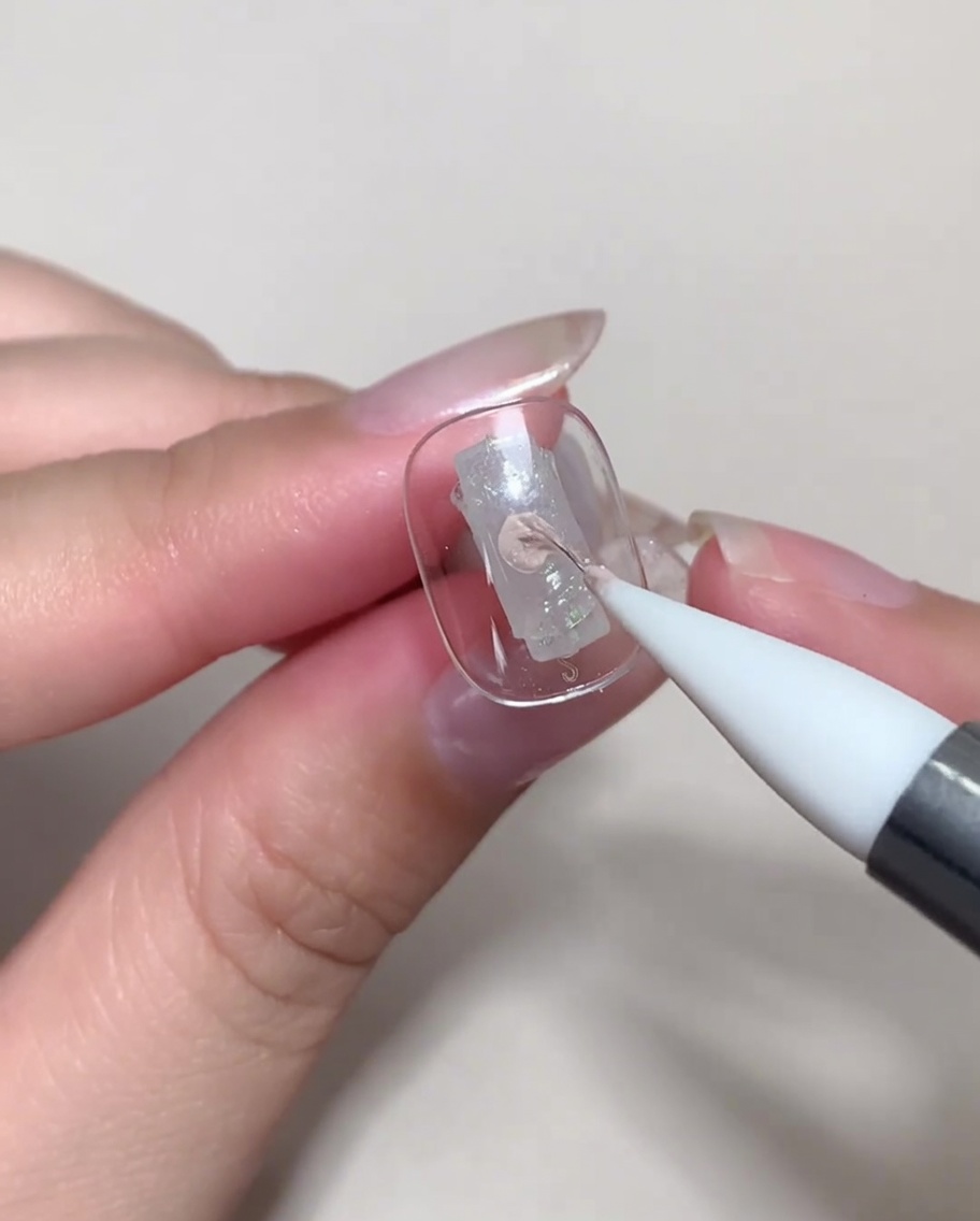 Una uña colocada bajo una lámpara UV/LED para el proceso de curado.