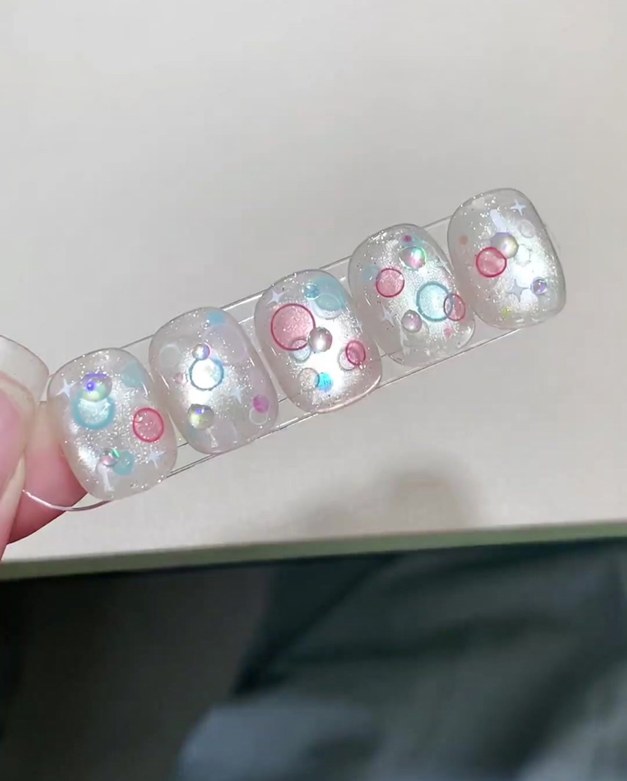 Una uña terminada con arte de burbujas 3D siendo curada dentro de una lámpara UV/LED.