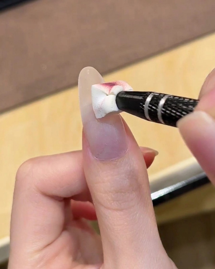 Una mano colocada bajo una lámpara UV profesional para el curado del gel.