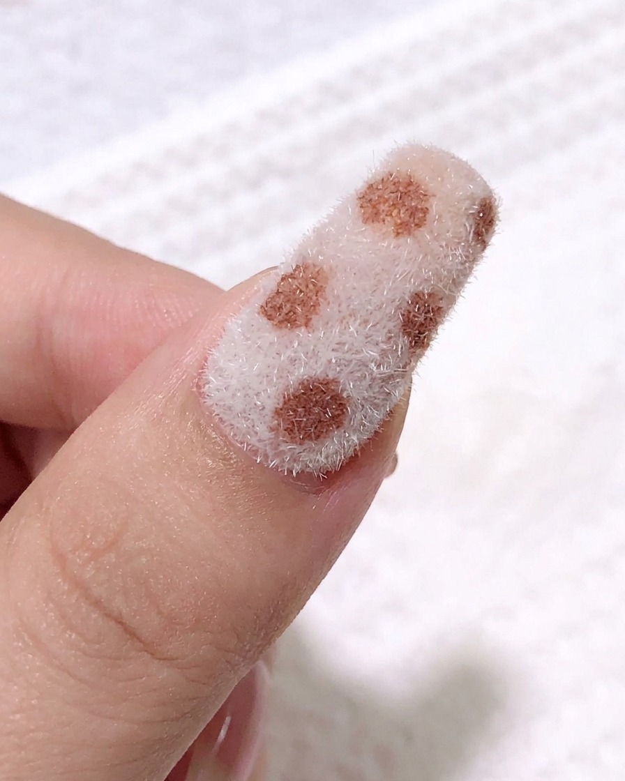 Primer plano usando un pincel fino para aplicar gel negro y crear contornos de leopardo sobre la superficie.