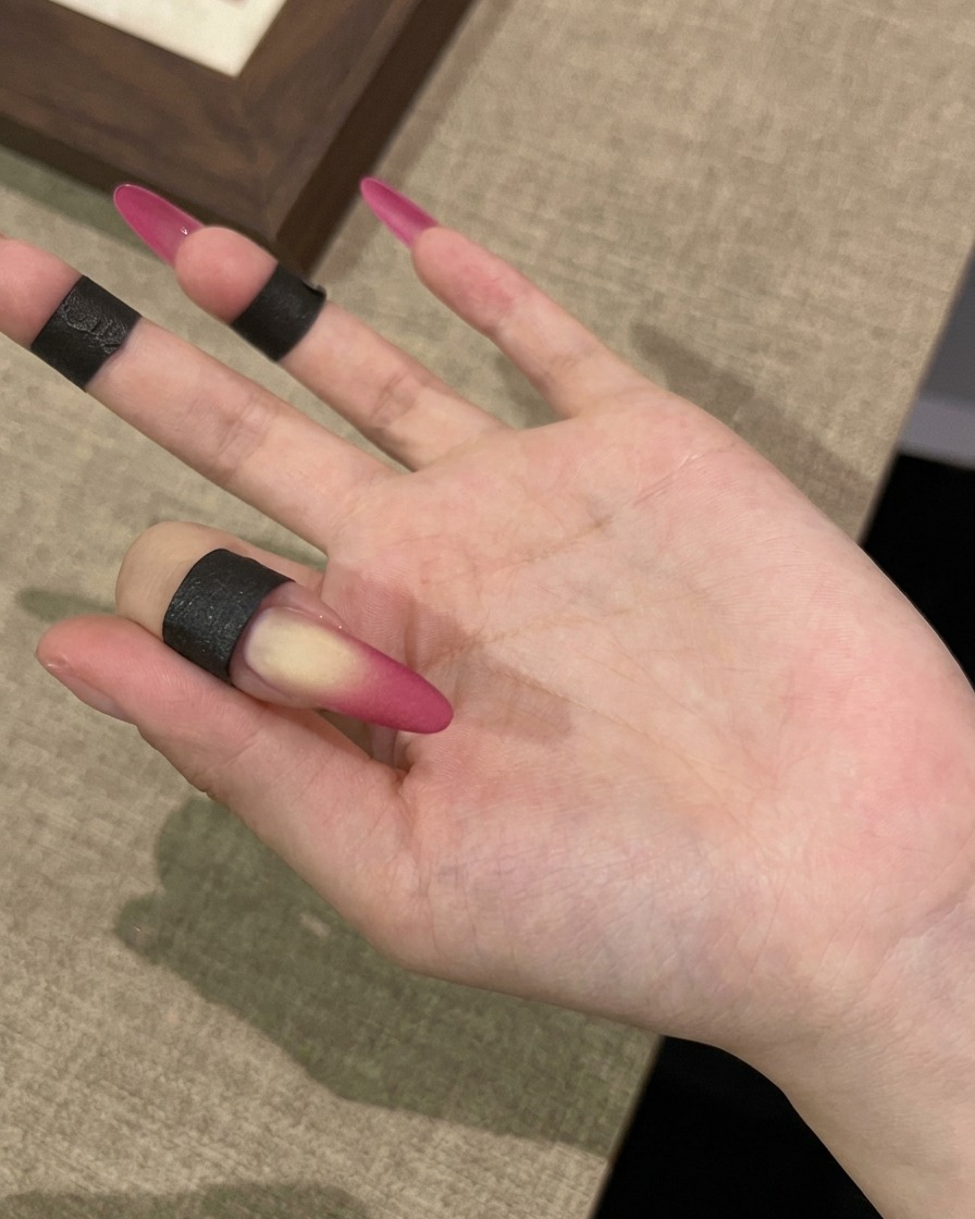 Una mano bajo una lámpara UV para el paso final de curado del look velvet mate.