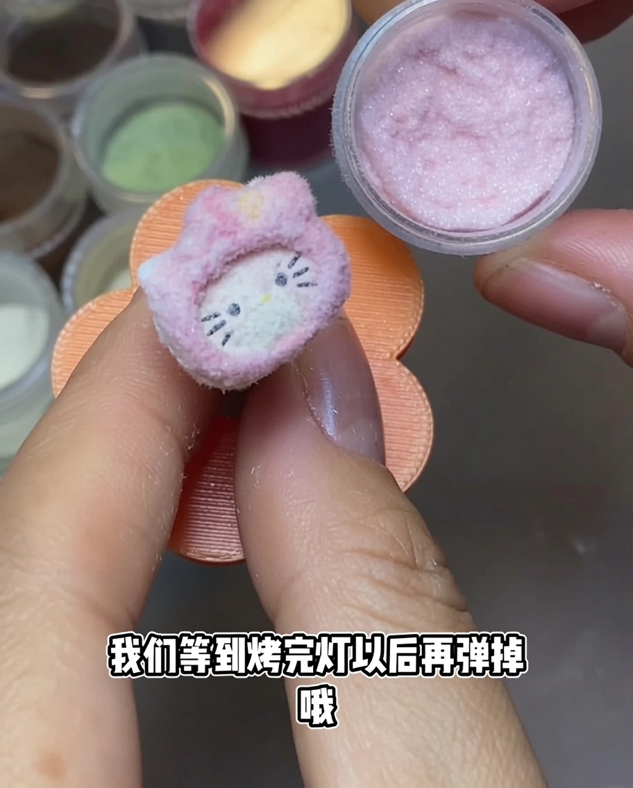 Un dije de uña de Hello Kitty bajo una lámpara de uñas UV portátil.