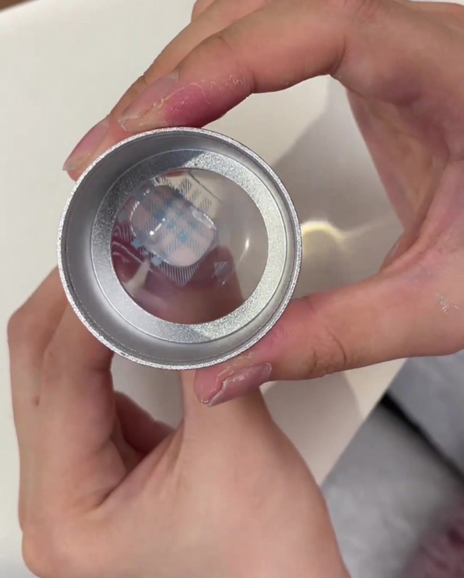 Un sello de silicona transparente que muestra el patrón de cuadros azules recogido de la placa de metal.