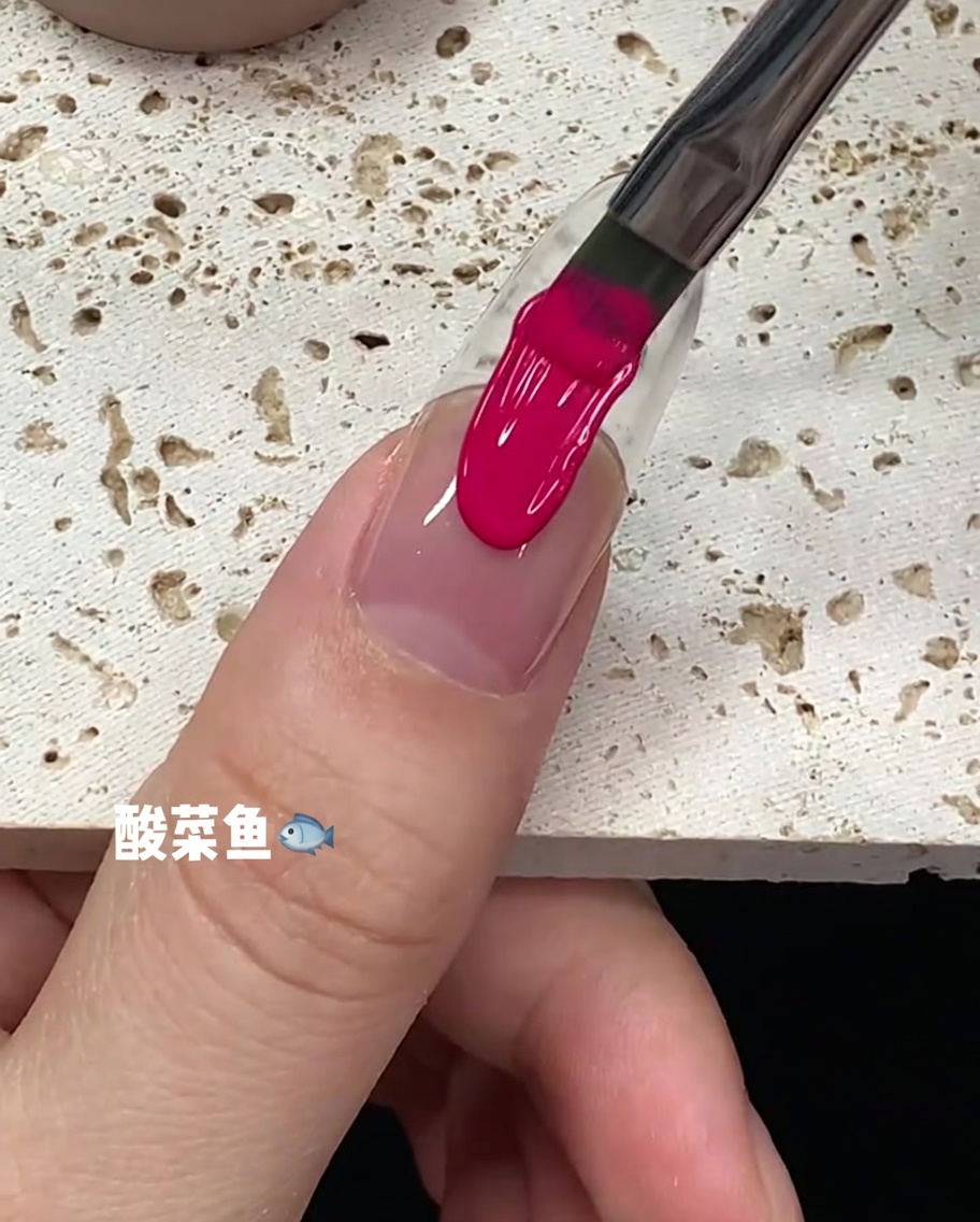 Una pincelada de esmalte de gel rosa brillante recorriendo el centro de la placa ungueal.
