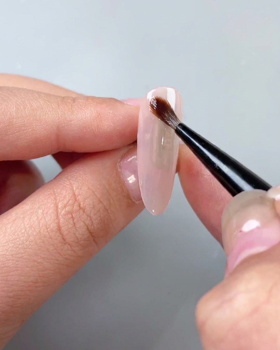 Un pincel aplicando gel acuarela transparente sobre una base.