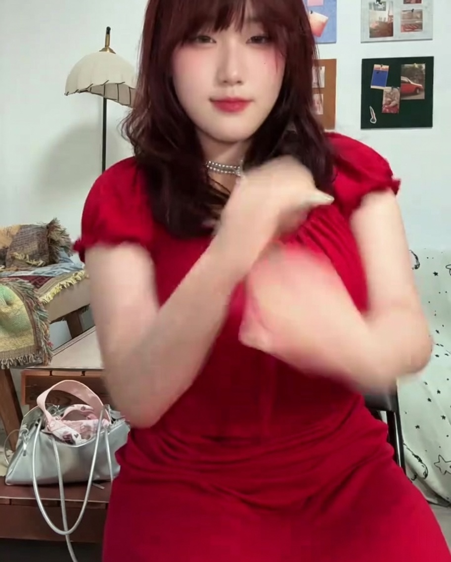 Un pincel aplicando esmalte de gel fucsia vibrante en las uñas del pulgar e índice.