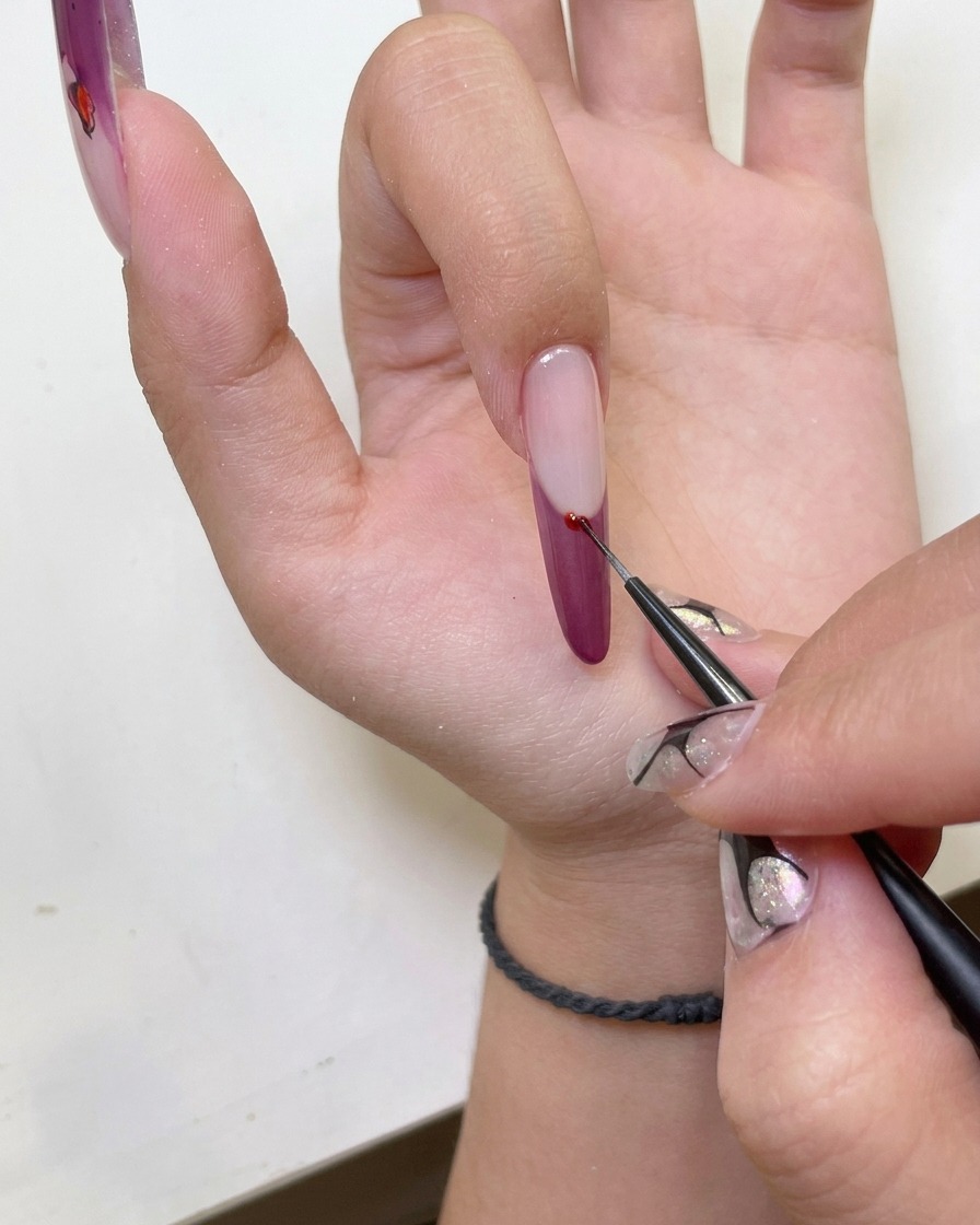 Primer plano de una mano con uñas con punta francesa ojo de gato colocadas dentro de una lámpara UV.