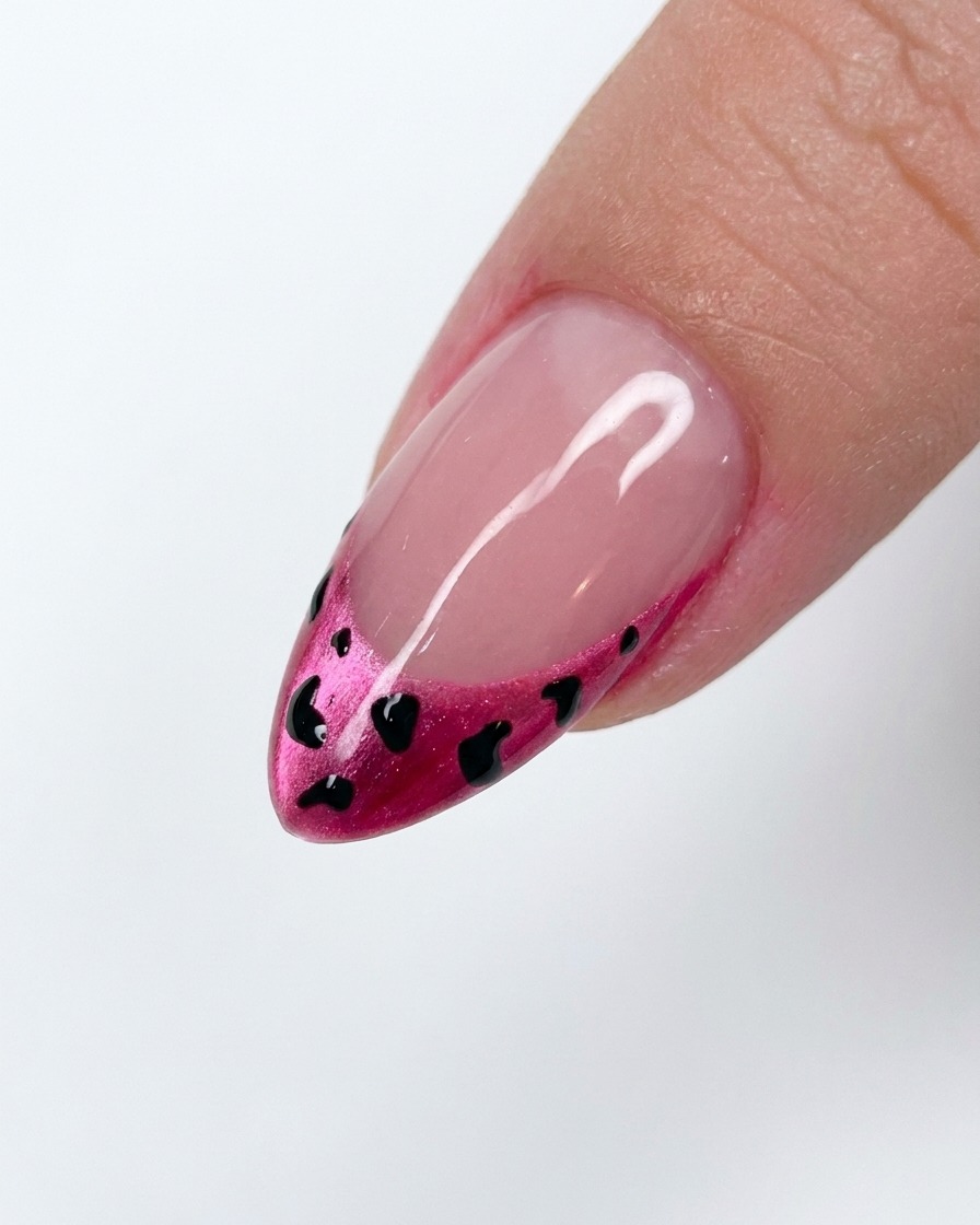 Una pequeña cantidad de polvo blanco siendo aplicado sobre un diseño de leopardo en gel húmedo.