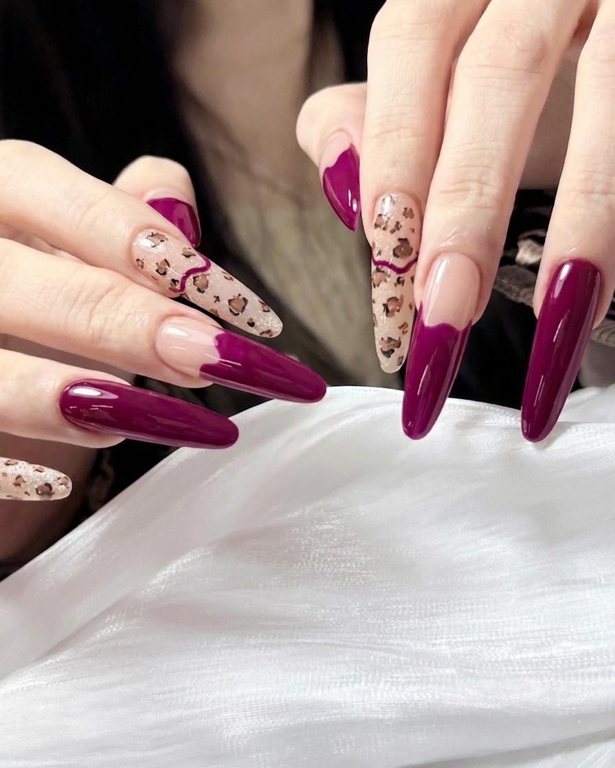 Un pincel aplicando una capa transparente de top coat de alto brillo sobre la manicura terminada en magenta y leopardo.