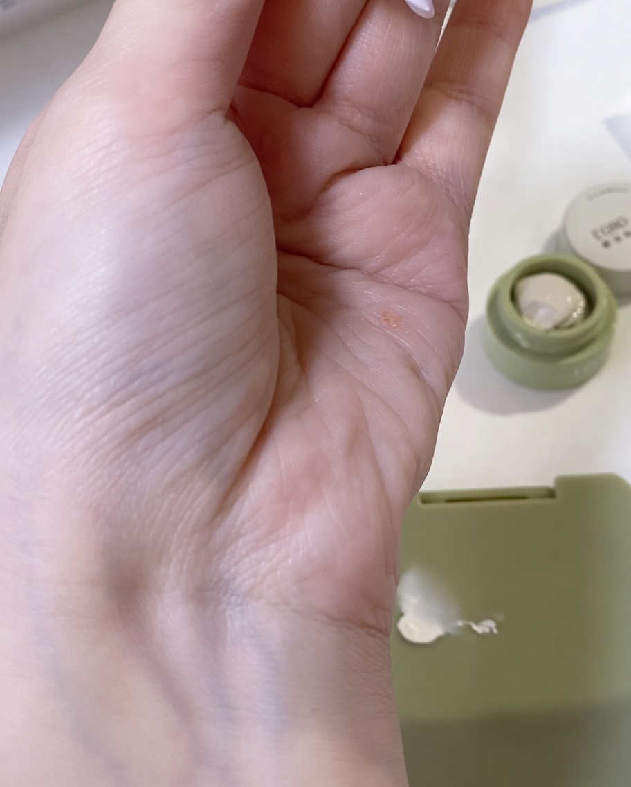 Una esponja de maquillaje siendo usada para difuminar un toque de gel blanco, creando una transición suave.