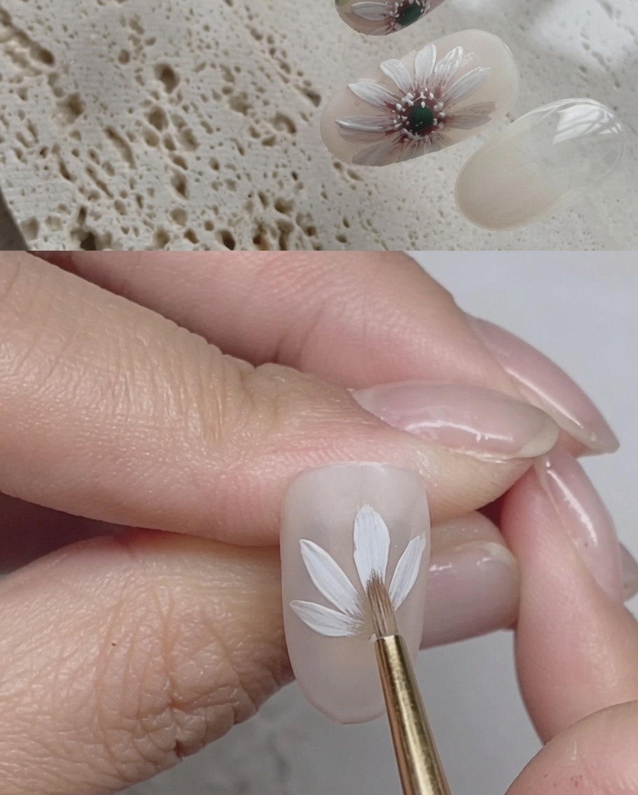 Primer plano de una uña con trazos de gel blanco creando una segunda capa de pétalos sobre la primera.