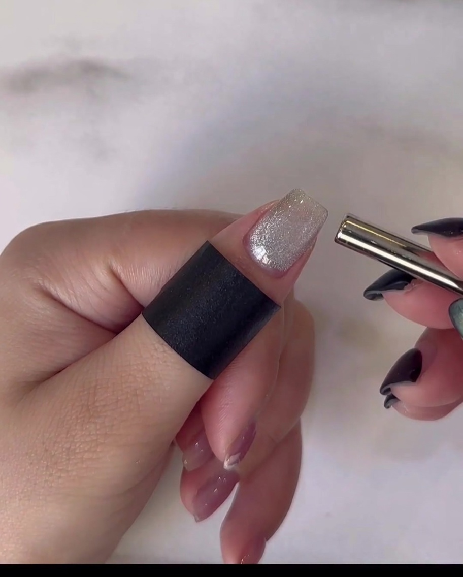 Una mano descansando dentro de una lámpara de uñas profesional UV/LED para curar la capa final de top coat.
