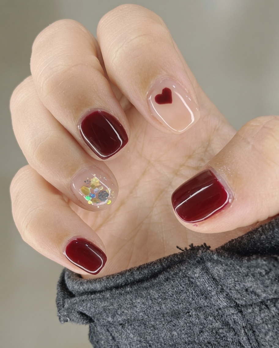 Un pincel aplicando un top coat brillante transparente sobre una uña decorada.