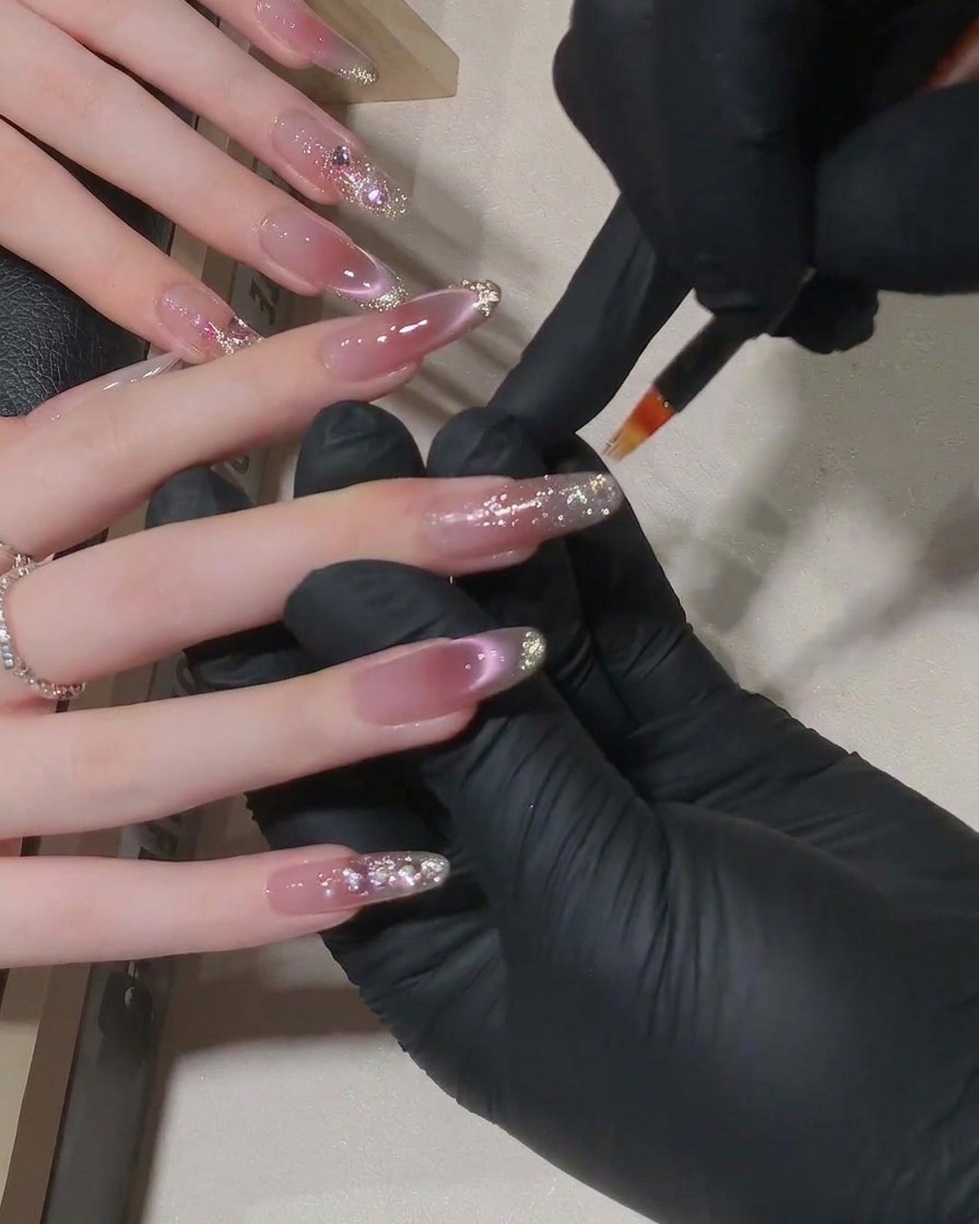 Un conjunto de uñas dentro de una lámpara LED curándose bajo una luz púrpura suave.