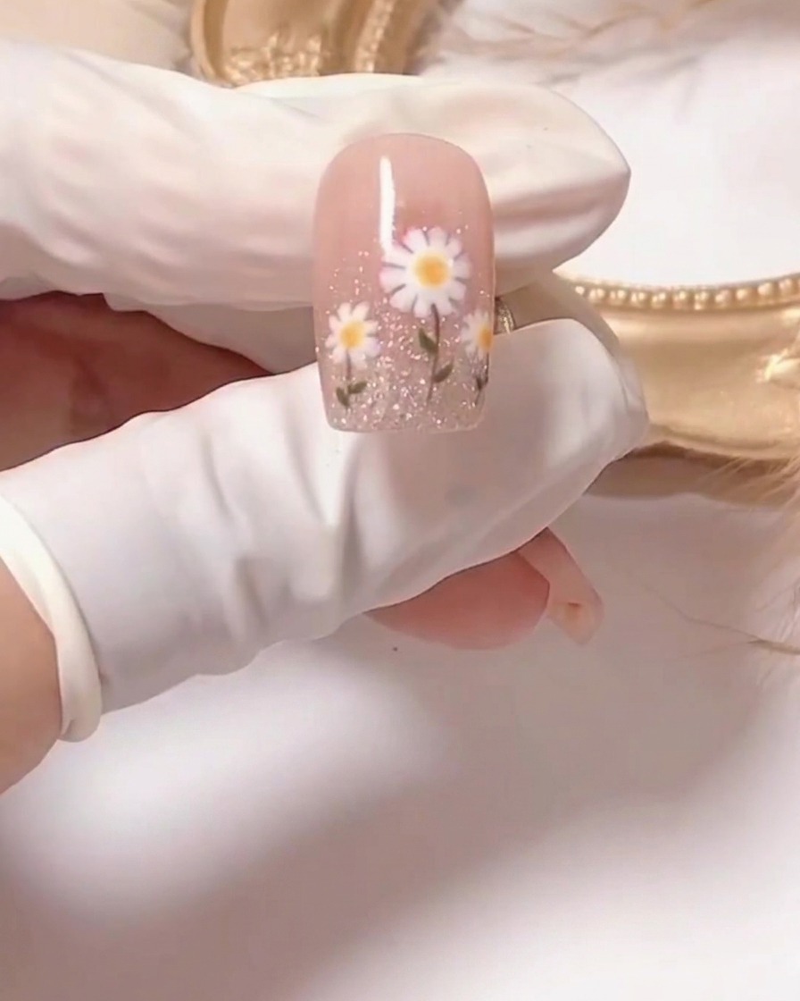 Primer plano de un pincel aplicando esmalte de gel rosa traslúcido sobre una uña preparada.
