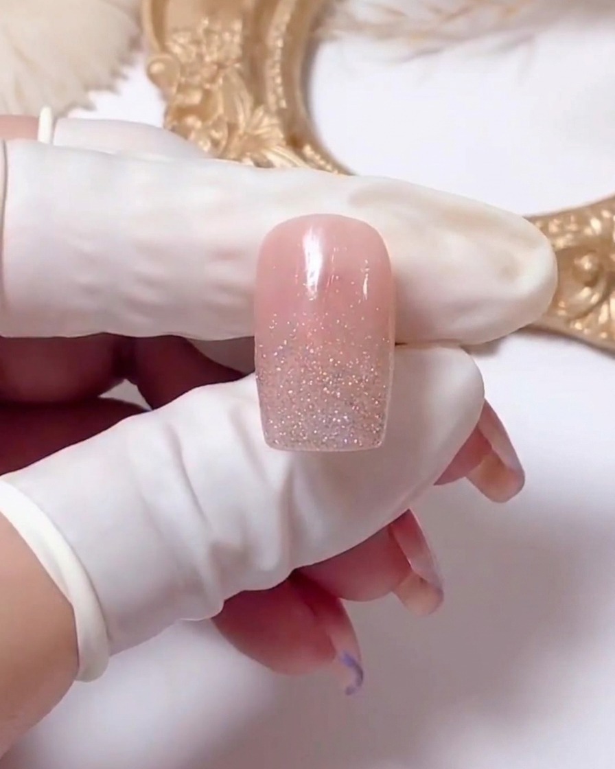 Primer plano de una uña mostrando líneas de gel blanco dibujadas en forma de X para iniciar el diseño de margarita.