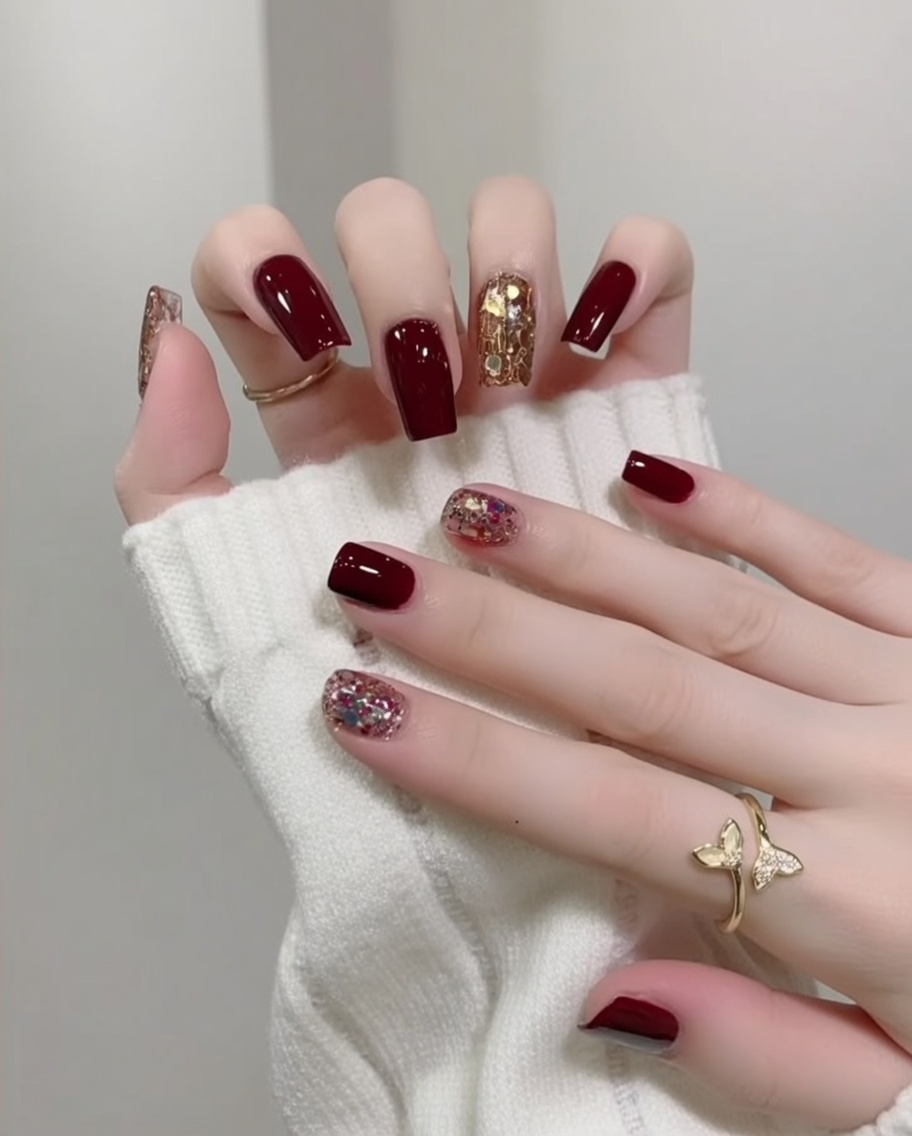 Una mano con uñas terminadas, brillantes y con brillo dentro de una lámpara UV/LED para el curado final.
