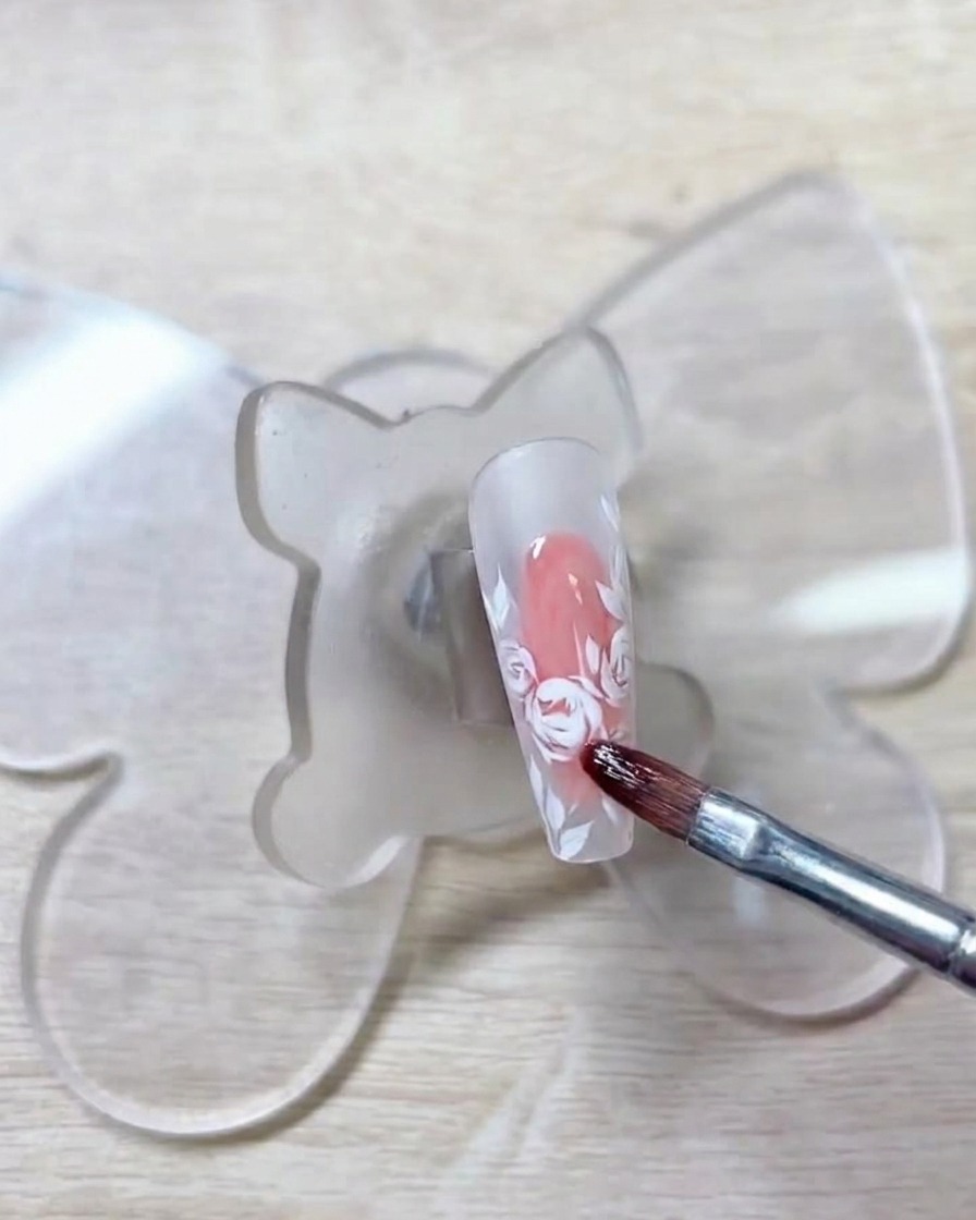Un pincel aplicando un gel rojo suave sobre los contornos blancos previos.