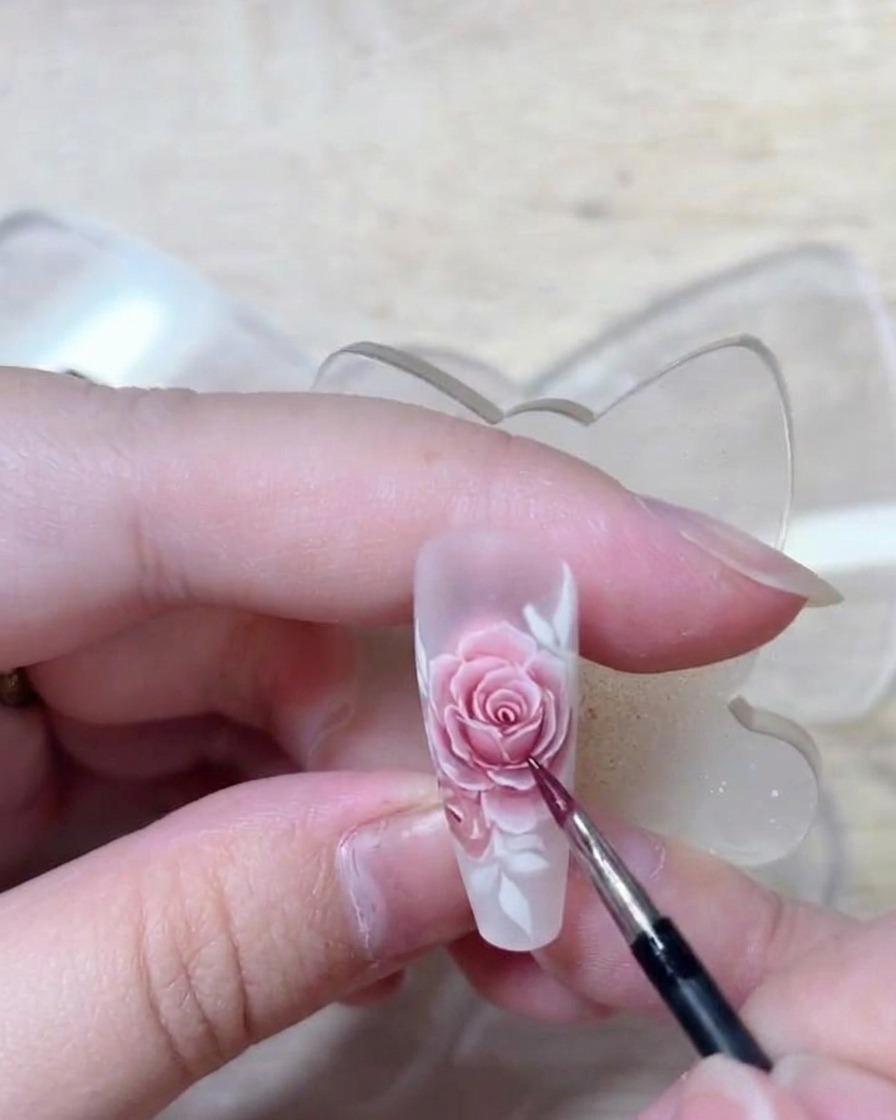 Primer plano de la uña con todas las rosas rellenas de rojo claro, mostrando transiciones y luces.