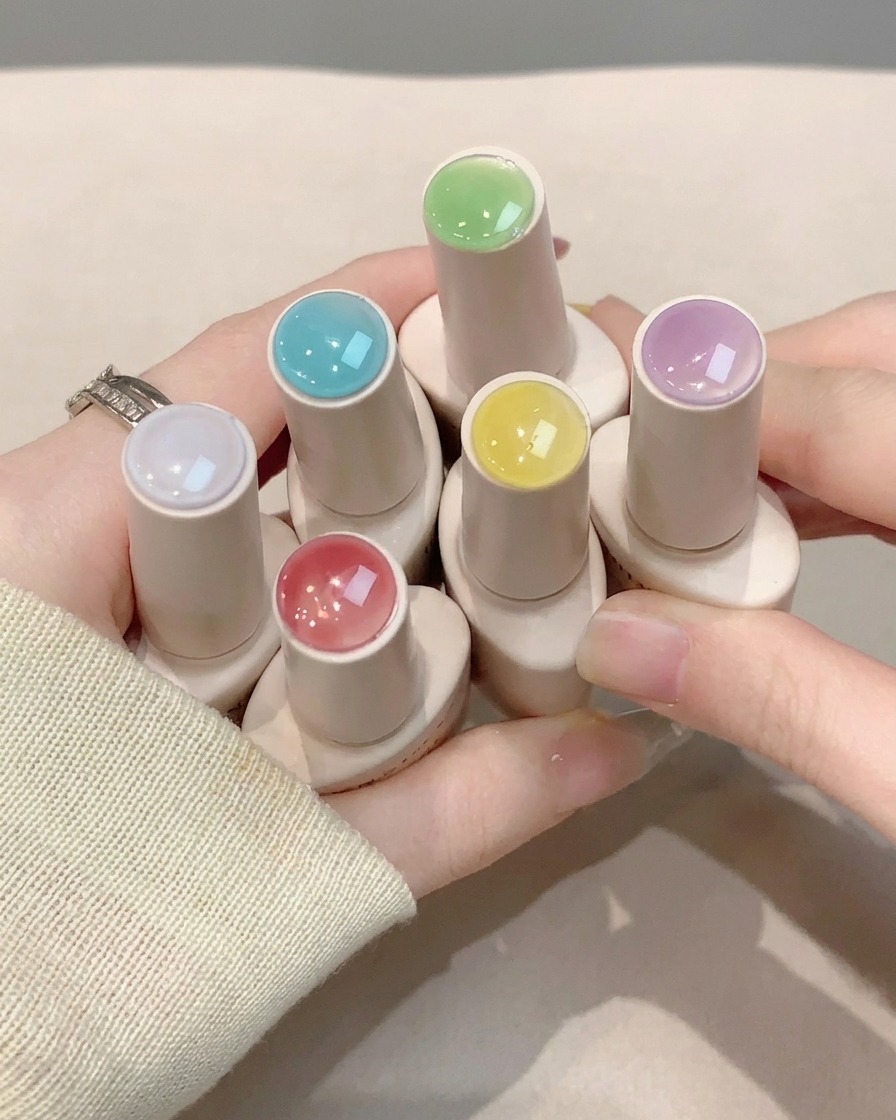 Un pincel de uñas aplicando una capa de brillo transparente sobre el nail art terminado.