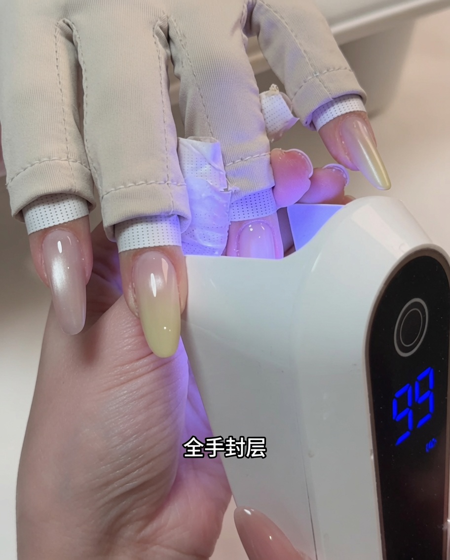Una mano posicionada dentro de una lámpara de uñas UV profesional durante el proceso de curado.