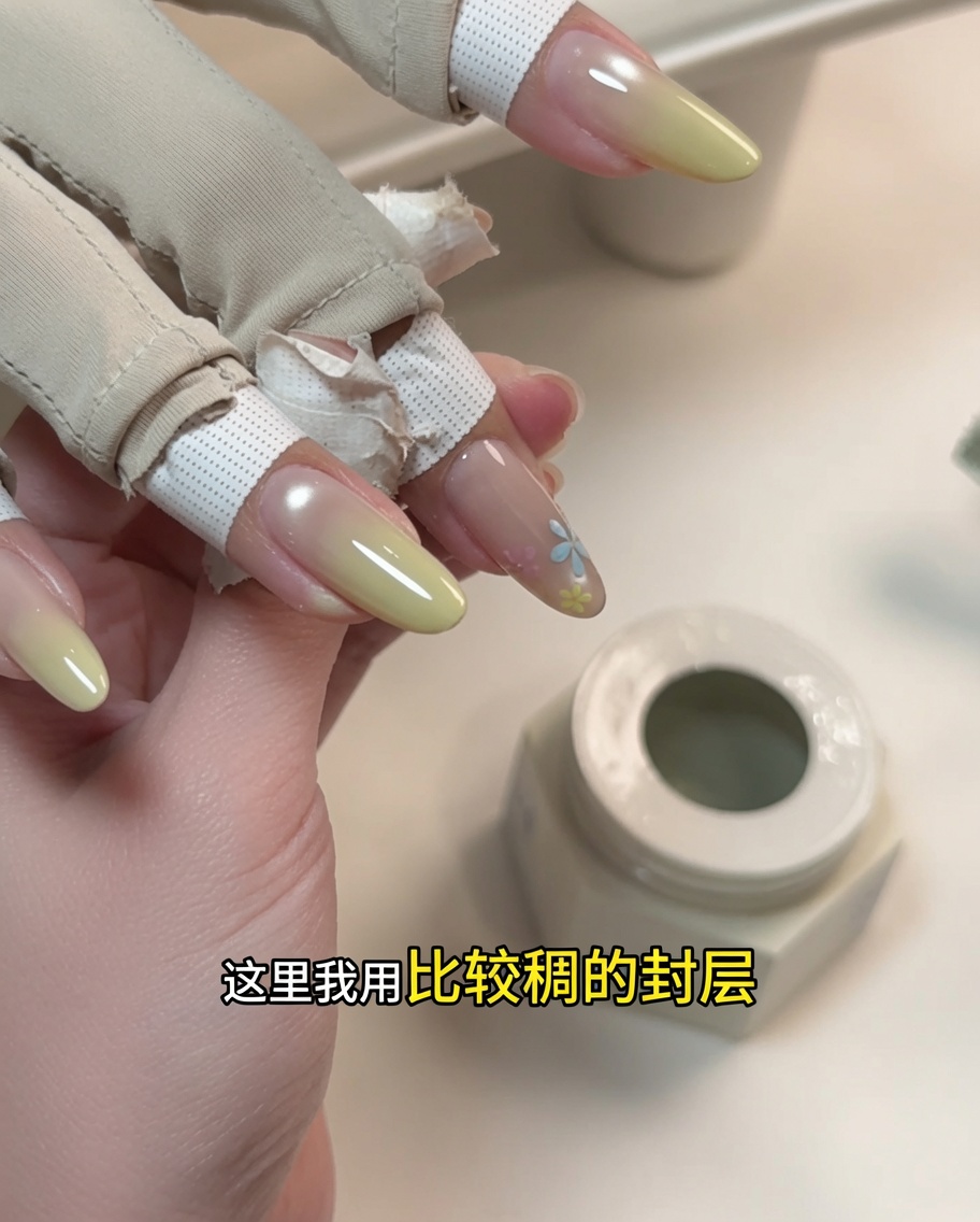 Un primer plano que muestra la aplicación de un gel de escultura espeso sobre un diseño floral pintado.