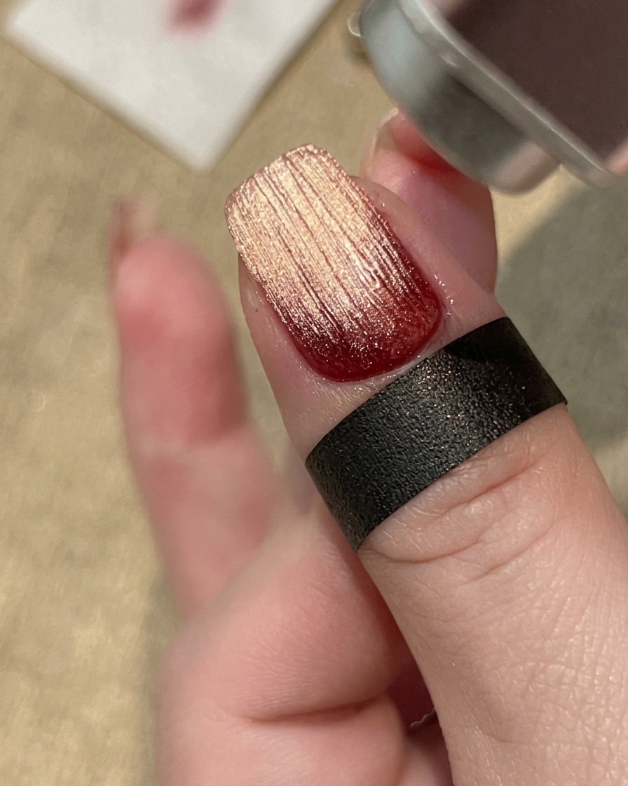Una mano curando un diseño de uñas con gel texturizado bajo una lámpara profesional UV/LED.