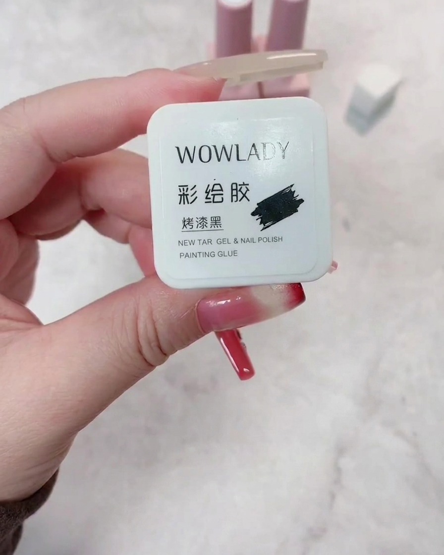 Un pincel aplicando esmalte de gel rojo oscuro sobre una uña preparada, asegurando una cobertura uniforme.