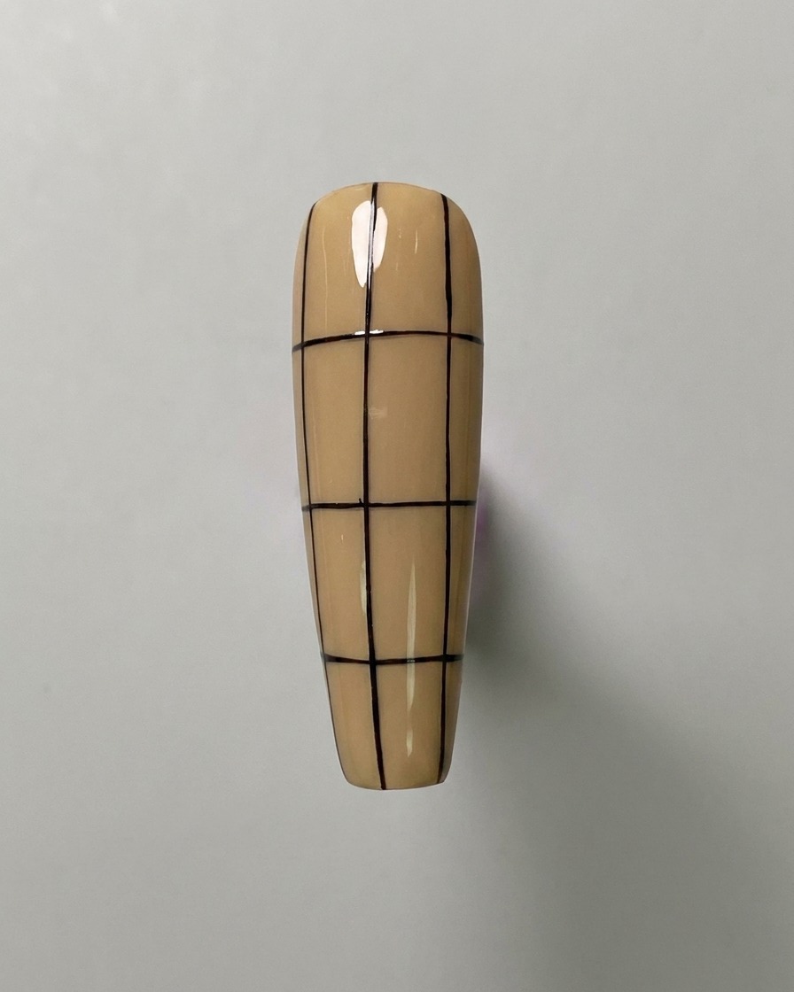 Una uña color nude con tres líneas verticales y tres líneas horizontales espaciadas uniformemente, creando un patrón de cuadrícula grande.