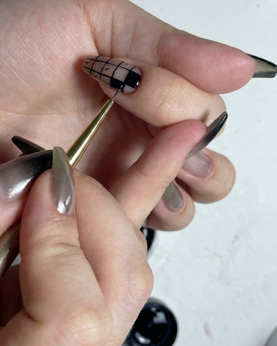 Pincel fino retocando los bordes de los cuadros negros rellenos para hacerlos más nítidos.