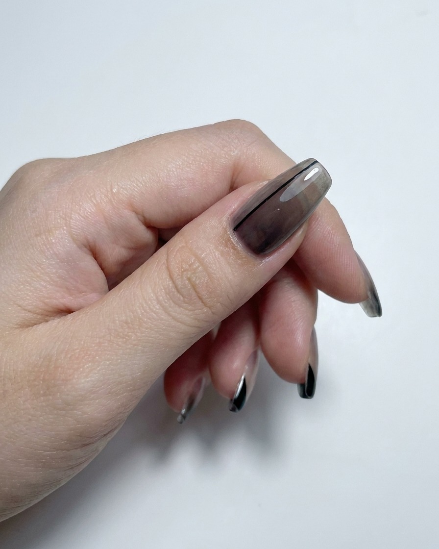 Mano mostrando uñas con degradado translúcido y puntas francesas selladas con un top coat de alto brillo.