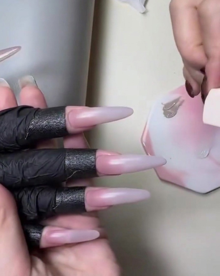 Una esponja aplicando gel en tono piel nude durante un tutorial de uñas con degradado.