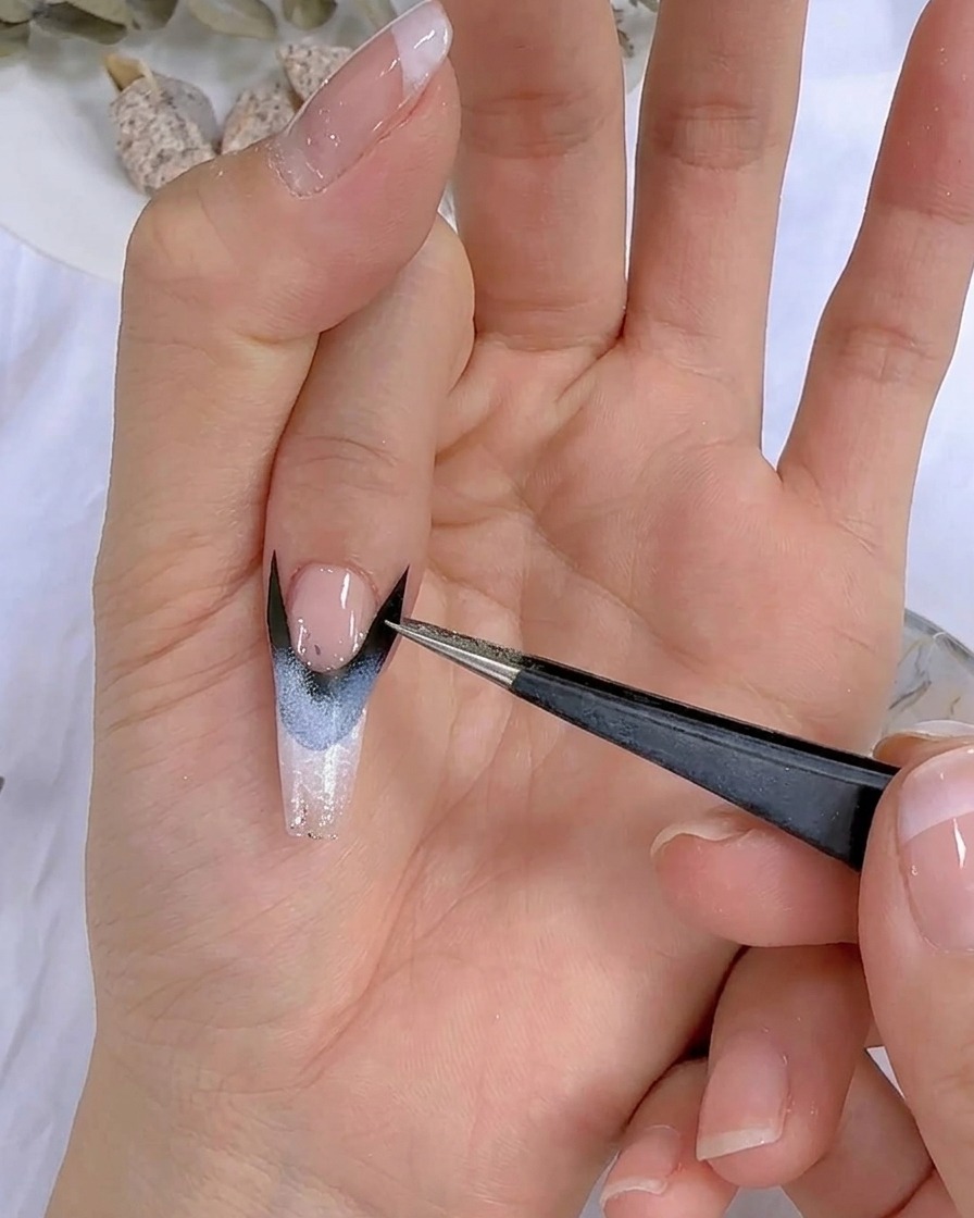 Primer plano de una mano con nail art colocada bajo una lámpara UV LED.