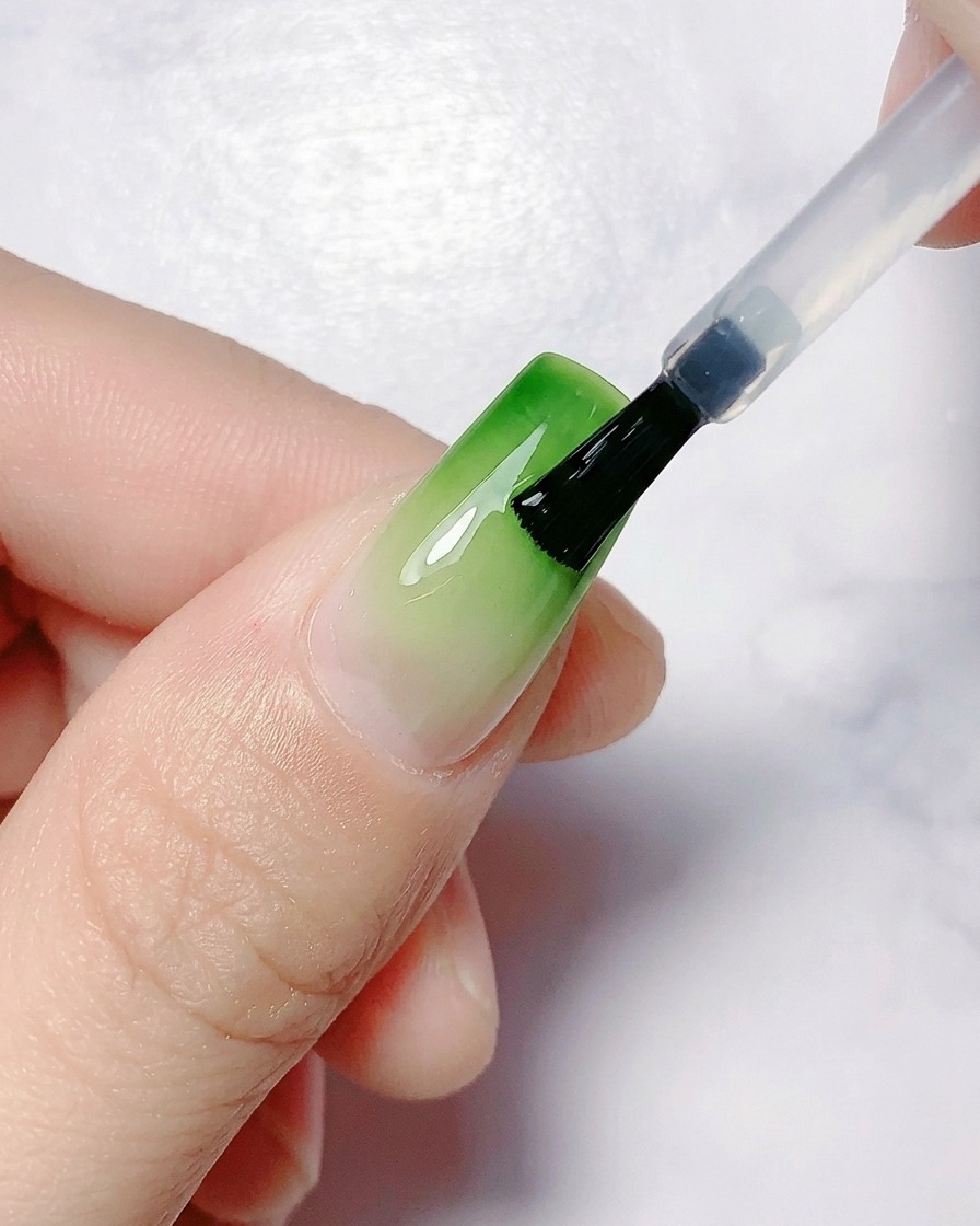 Una mano posicionada bajo una lámpara de uñas UV/LED para el curado.