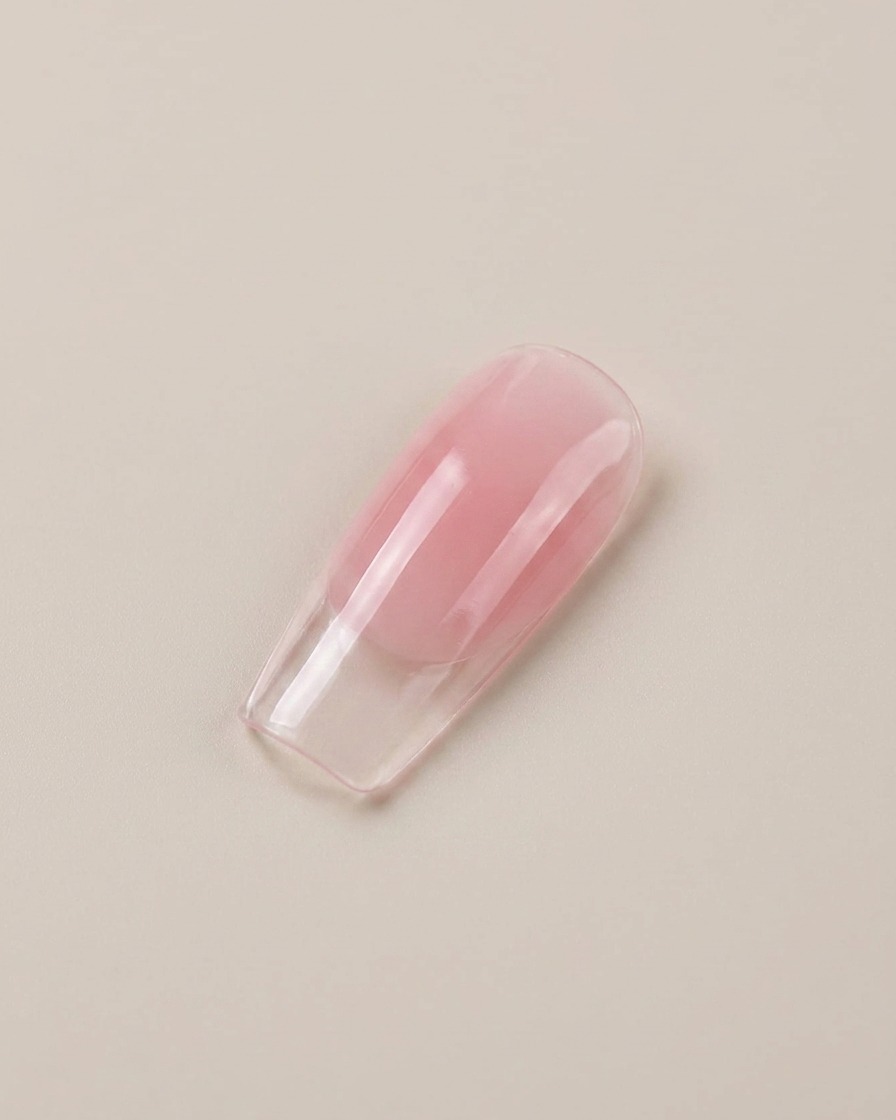 Primer plano de una punta de uña artificial brillante y translúcida de color rosa.