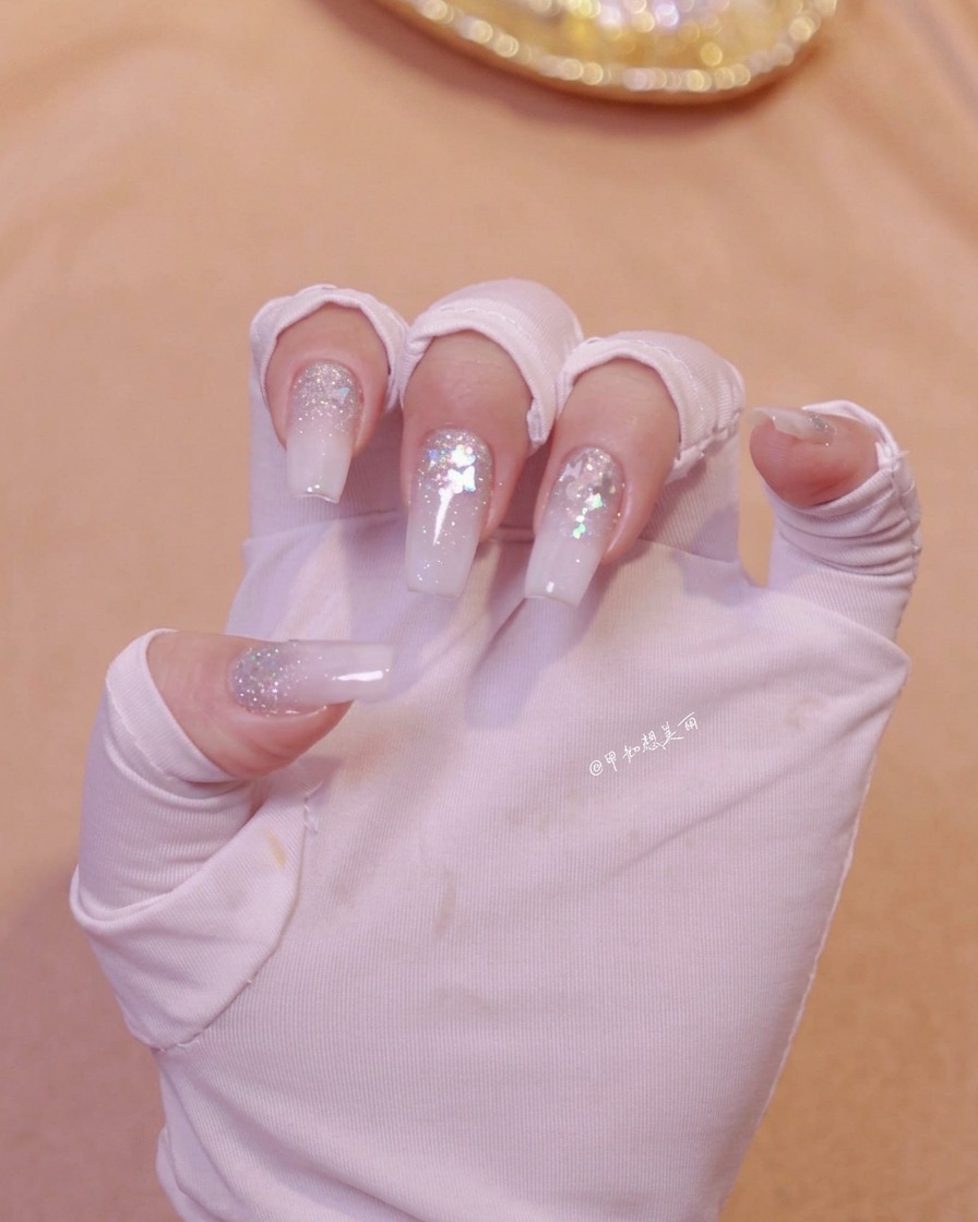 Una mano posicionada bajo una lámpara de uñas para curar la capa de arte de uñas recién aplicada.