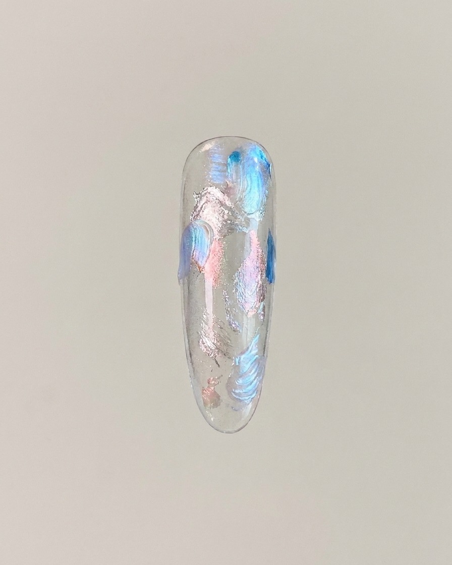 Una punta de uña que muestra gel de ojo de gato magnetizado en un centro brillante con efecto de bola de vidrio.