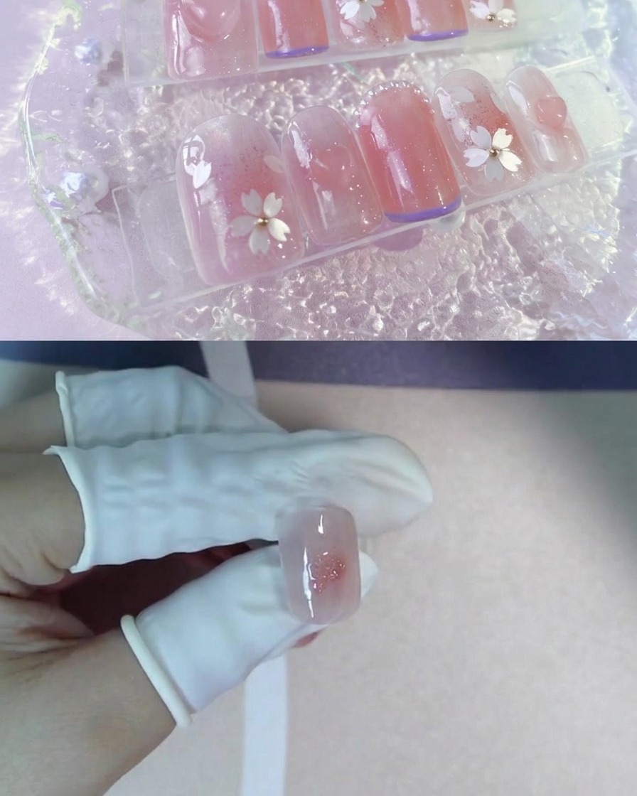 Un dedo enguantado sosteniendo la punta de una uña con un centro de rubor rosa y un punto de gel brillante.