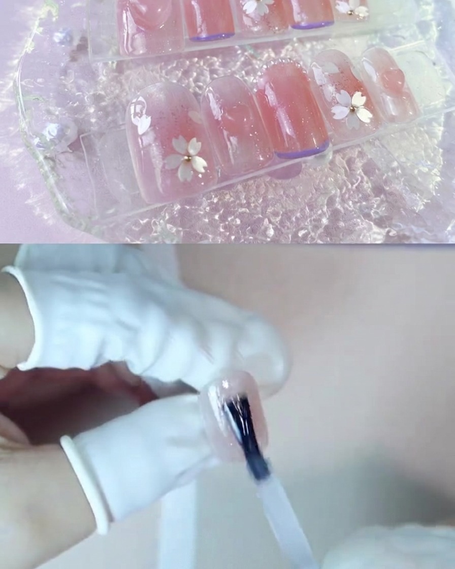 Una mano aplicando una capa de gel de refuerzo transparente sobre una uña rosa con efecto rubor.