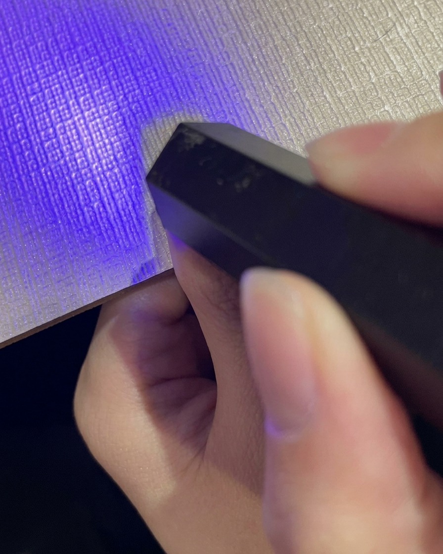 Aplicando una capa de esmalte de gel con purpurina cat eye reflectante sobre la uña degradada.